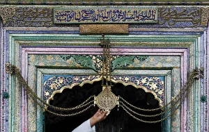 Kashmiri man touches chain tied to gate of shrine during Ramadan in Srinagar Kashmiri man touches chain tied to gate of shrine during Ramadan in Srinagar