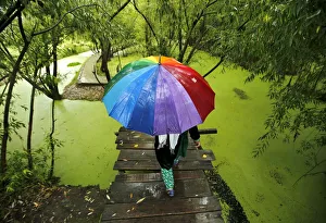 Kashmiri woman walks on a footbridge as it rains in Srinagar Kashmiri woman walks on a footbridge as it rains in Srinagar