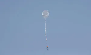 Kite loaded with a flammable material is flown by Palestinian demonstrators to be thrown Kite loaded with a flammable material is flown by Palestinian demonstrators to be thrown