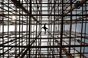 Abstracts Gallery: A labourer walks across scaffolding at a construction site in Wuhan