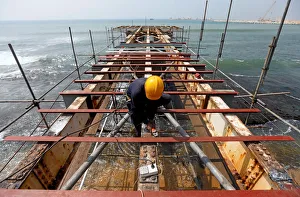 A labourer works at a construction site of a bridge on the sea in Colombo A labourer works at a construction site of a bridge on the sea in Colombo