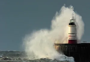 Large waves of the English Channel hit the light beacon and seawall at Newhaven in Large waves of the English Channel hit the light beacon and seawall at Newhaven in