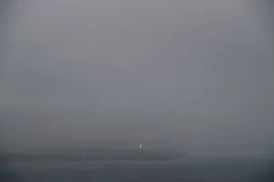 The lighted cross of Chorrillos is seen from a cliff overlooking the Pacific ocean in the The lighted cross of Chorrillos is seen from a cliff overlooking the Pacific ocean in the