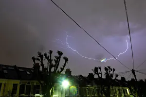 Lightning is seen from a bedroom window as it strikes above a street in south London Lightning is seen from a bedroom window as it strikes above a street in south London