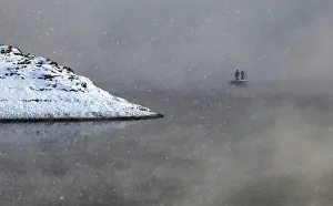 Two local residents row on a boat through a frosty fog as they cross the Shumikha Two local residents row on a boat through a frosty fog as they cross the Shumikha