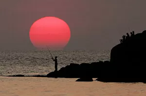 Images Dated 16th February 2005: A local Thai man fishes at sunset near Patong Beach on the Thai resort island of Phuket