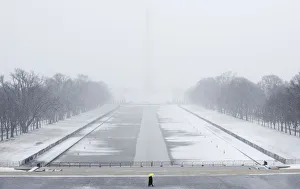 A lone tourist walks on the National Mall near the Lincoln Memorial during a snow storm A lone tourist walks on the National Mall near the Lincoln Memorial during a snow storm