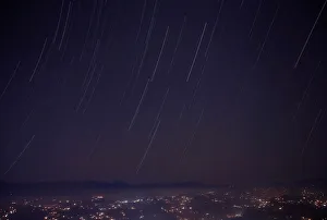 A long exposure picture shows a star trail above the mountain range during the Geminids A long exposure picture shows a star trail above the mountain range during the Geminids
