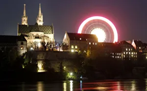 A long time exposure shows a ferris wheel turning beside Basels landmark the Muenster A long time exposure shows a ferris wheel turning beside Basels landmark the Muenster