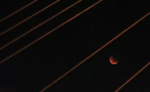 Images Dated 15th June 2011: A lunar eclipse is visible among cables on the Anzac Bridge in Sydney