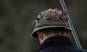 Lures are seen on an anglers hat on the opening day of the salmon fishing season on the Lures are seen on an anglers hat on the opening day of the salmon fishing season on the