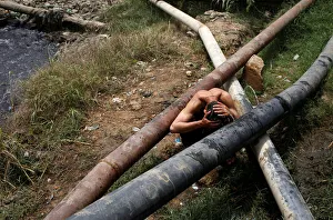 A man cools off near a leaking water pipeline, during hot and humid weather in Karachi A man cools off near a leaking water pipeline, during hot and humid weather in Karachi