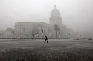 A man crosses the street during thunderstorms in Havana A man crosses the street during thunderstorms in Havana