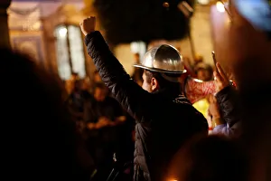 A man gestures during a minute of silence with others as they mark the four-month A man gestures during a minute of silence with others as they mark the four-month