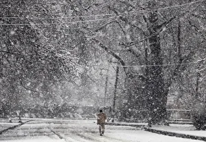A man holding an umbrella walks during snowfall in Srinagar A man holding an umbrella walks during snowfall in Srinagar