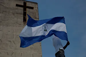 A man holds up a Nicaraguan flag during a protest march to demand an end to violence in A man holds up a Nicaraguan flag during a protest march to demand an end to violence in
