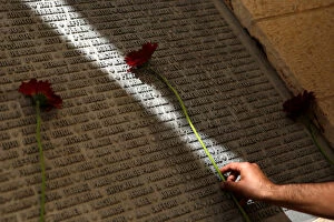 Images Dated 11th September 2016: A man lays a flower on a monument engraved with names of victims of the September 11th