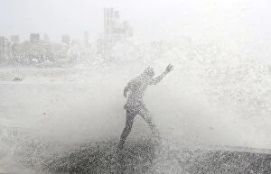 Power Of Nature Gallery: A man loses his balance as he gets drenched by a large wave during high tide at a