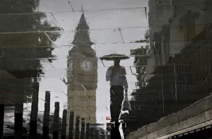 A man is reflected next to Big Ben on a wet pavement during a rainy day in central London A man is reflected next to Big Ben on a wet pavement during a rainy day in central London