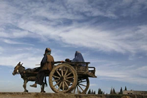 Images Dated 23rd November 2011: A man rides a cart led by a donkey through the outskirts of Quetta