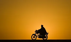 A man rides a motorcycle as the sun sets at Delaram district in Nimroz province A man rides a motorcycle as the sun sets at Delaram district in Nimroz province