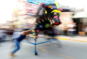 Firework Gallery: Man spins a traditional bull figure surrounded by fireworks, known as El Torito