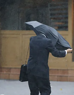 A man struggles against a strong wind and rain caused by approaching Typhoon Wipha at a A man struggles against a strong wind and rain caused by approaching Typhoon Wipha at a