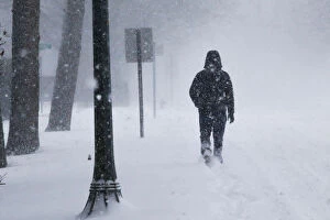A man struggles against wind and snow during Storm Grayson at the Jersey shore in