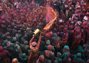 A man throws coloured water as he celebrates Lathmar Holi at Nandgaon A man throws coloured water as he celebrates Lathmar Holi at Nandgaon