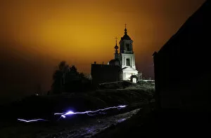 A man uses a torch as he leaves a church after an Orthodox Easter night mass in the