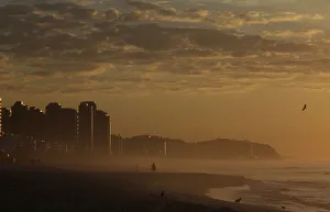 A man walks in Barra da Tijuca beach during the sunrise in Rio de Janeiro A man walks in Barra da Tijuca beach during the sunrise in Rio de Janeiro