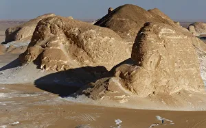 A man walks near rocks which are known as Ajabaat Rocks in the White Desert near A man walks near rocks which are known as Ajabaat Rocks in the White Desert near