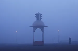 A man walks on a road amidst heavy fog on a winter morning in New Delhi A man walks on a road amidst heavy fog on a winter morning in New Delhi