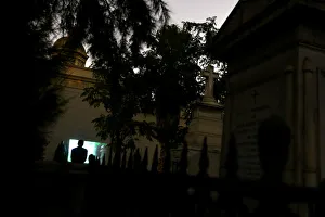 A man watches a movie in a cemetery as part of Ghost Tour heritage circuit, in Santiago A man watches a movie in a cemetery as part of Ghost Tour heritage circuit, in Santiago