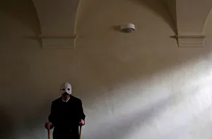 A man wearing a mask prepares to march through the streets during Easter celebrations in A man wearing a mask prepares to march through the streets during Easter celebrations in