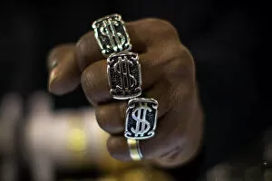 Strong Collection: A man wears dollar sign rings in a jewellery shop in Manhattan in New York City