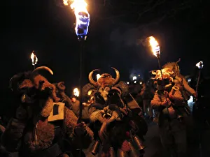 Men dressed in animal costumes, called kuker , carry torches during a festival in the Men dressed in animal costumes, called kuker , carry torches during a festival in the