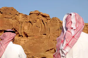 Men look at a camel sculpture carved on a rock in Al-Jouf Men look at a camel sculpture carved on a rock in Al-Jouf