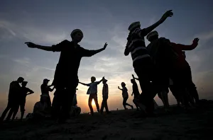 Men are silhouetted as they dance to celebrate during sunset at a beach in Karachi Men are silhouetted as they dance to celebrate during sunset at a beach in Karachi