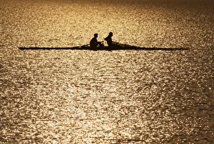 Men are silhouetted in the rising sun as they row in the waters of Sukhana Lake in Men are silhouetted in the rising sun as they row in the waters of Sukhana Lake in