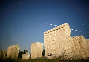 A meteor streaks past stars in the night sky above medieval tombstones during the A meteor streaks past stars in the night sky above medieval tombstones during the
