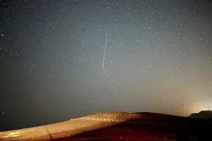 A meteor streaks across the sky in the early morning during the Perseid meteor shower in A meteor streaks across the sky in the early morning during the Perseid meteor shower in