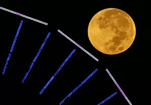 Images Dated 8th October 2014: The moon is pictured behind a ferris wheel on the pier in Santa Monica, California