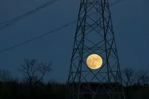 Images Dated 24th December 2015: The full moon rises behind a hydro tower on Christmas eve in Ottawa