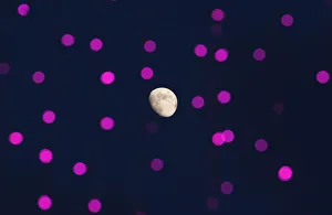 The moon is seen behind decorative lights prepared for the upcoming Mid-Autumn or Moon The moon is seen behind decorative lights prepared for the upcoming Mid-Autumn or Moon