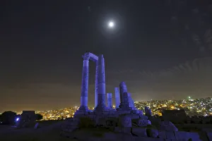 The moon is seen over the Roman pillars of the Temple of Hercules as it is lit up in blue The moon is seen over the Roman pillars of the Temple of Hercules as it is lit up in blue