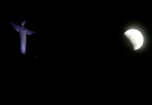 The moon is seen next to the statue of Christ the Redeemer during a total lunar eclipse The moon is seen next to the statue of Christ the Redeemer during a total lunar eclipse