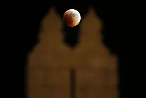 Images Dated 15th June 2011: The moon is seen behind the wall of Damascus gate in Jerusalem Old City during a total