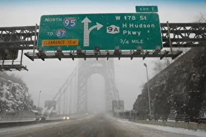 A nearly empty snow-covered roadway entrance to the George Washington Bridge between New A nearly empty snow-covered roadway entrance to the George Washington Bridge between New