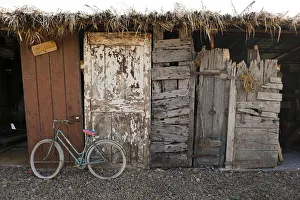 An old bicycle and old doors of different ages are seen in a storage of the Museum An old bicycle and old doors of different ages are seen in a storage of the Museum